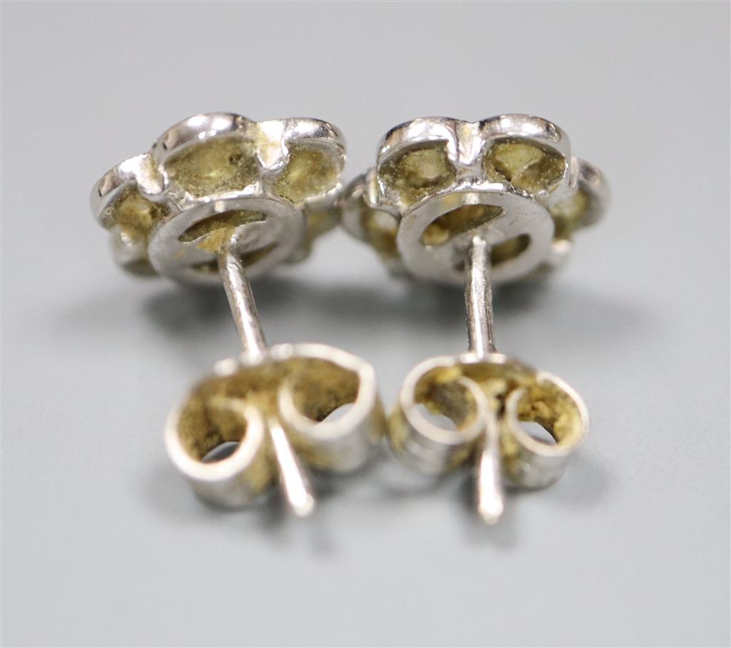 A pair of white metal and seven stone diamond set flower head cluster earrings, 8mm, gross 2.6 grams.